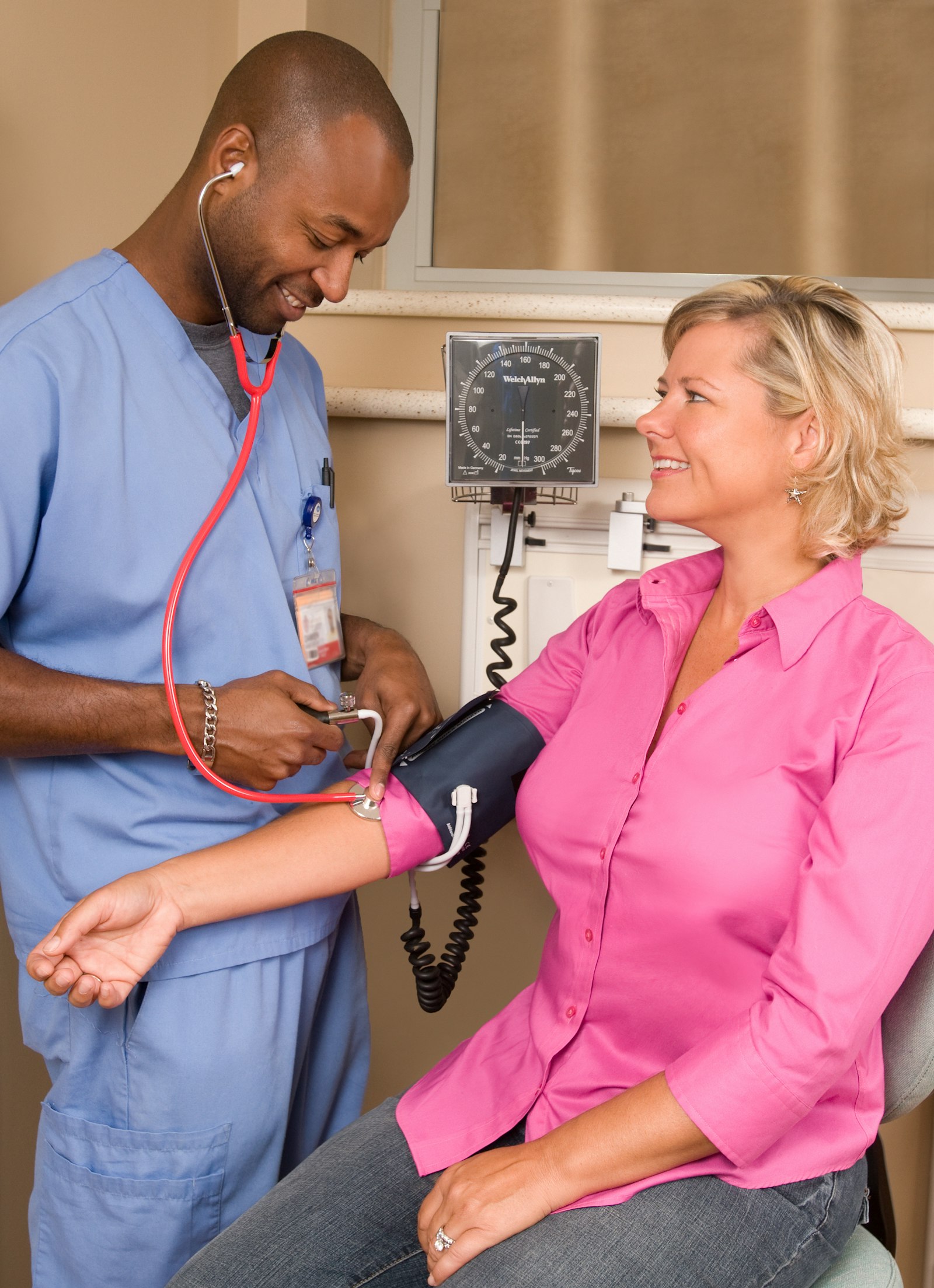 Nurse checking a client's blood pressure during a home visit